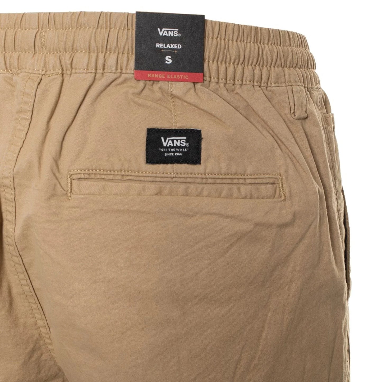 Close-up of beige Vans men's pants with elastic waistband and visible Vans logo on the back pocket and label.